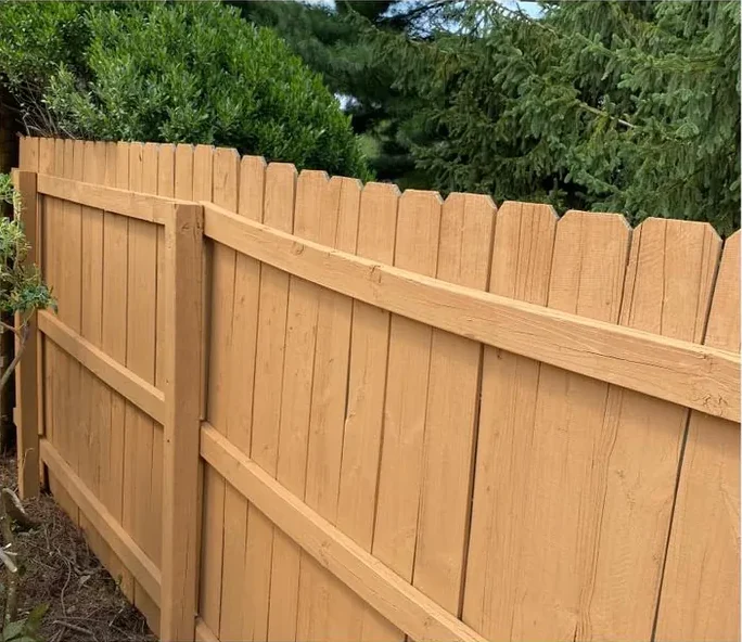 After: the same fence cleaned and stained a warm brown