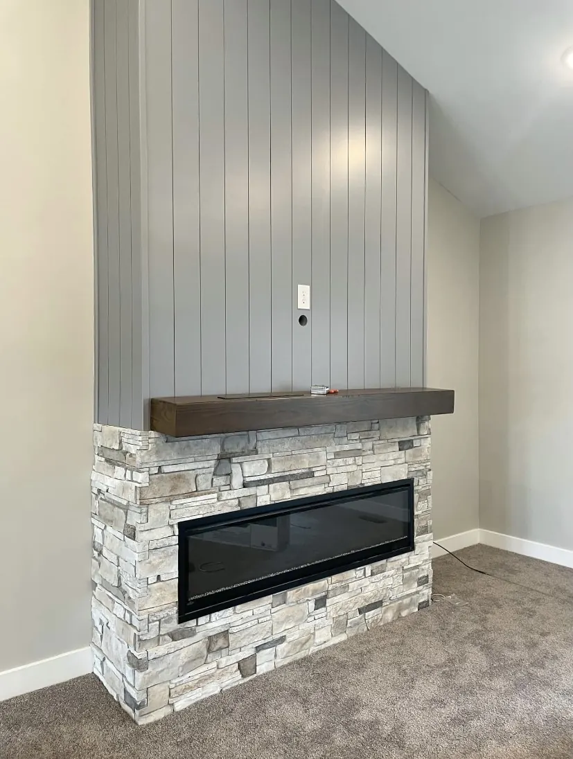 Gray shiplap fireplace wall with a stone surround