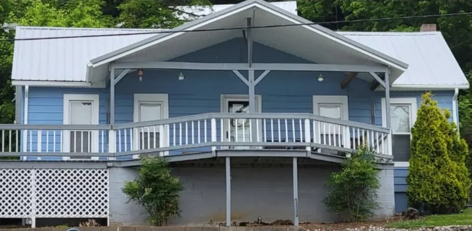 After: the same house repainted blue with white railings