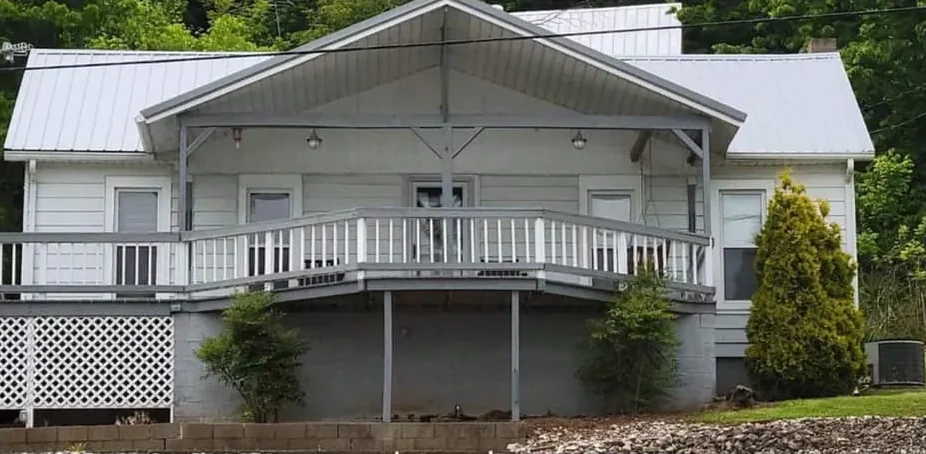 Before: a two-story house with white siding and gray trim
