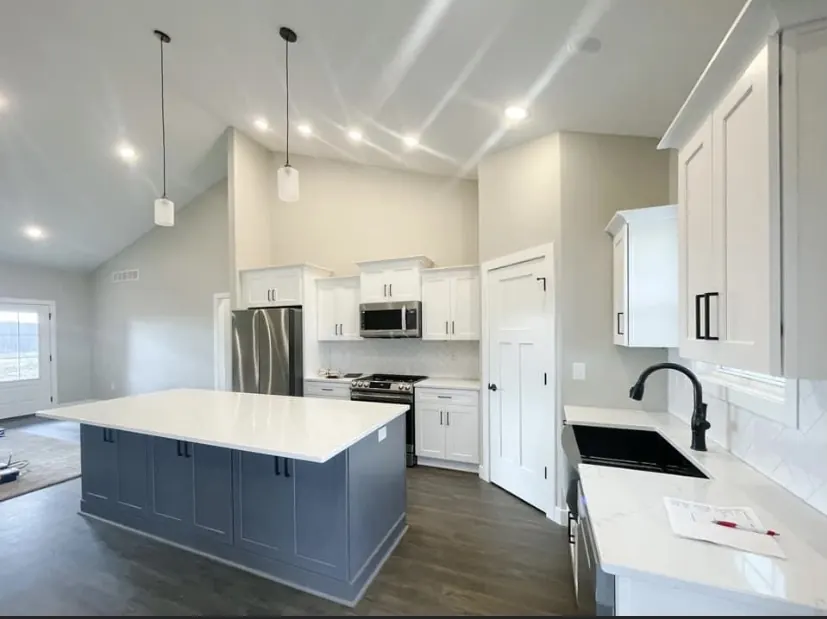 Kitchen with white cabinets and a slate blue island
